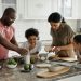 family of four making breakfast together in the kitchen