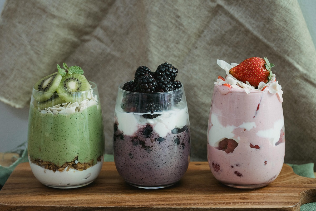 kiwi, blueberry, and strawberry yogurt parfait on a wooden chopping board